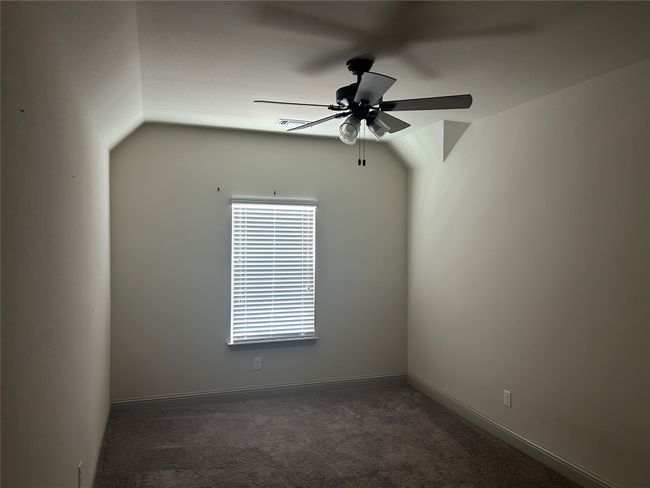 Carpeted spare room with ceiling fan, baseboards, and vaulted ceiling | Image 12