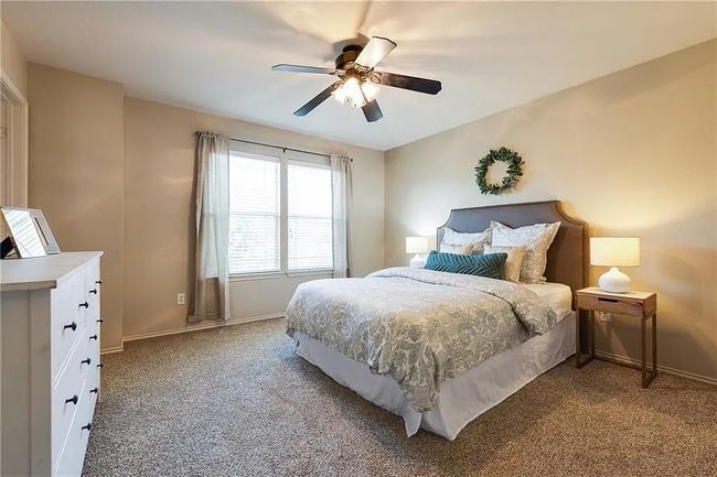 Bedroom featuring light colored carpet, baseboards, and a ceiling fan | Image 9