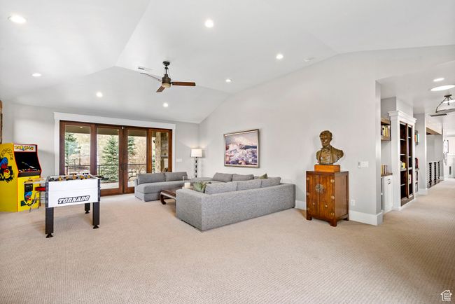 Carpeted living area with ceiling fan, baseboards, lofted ceiling, and recessed lighting | Image 59