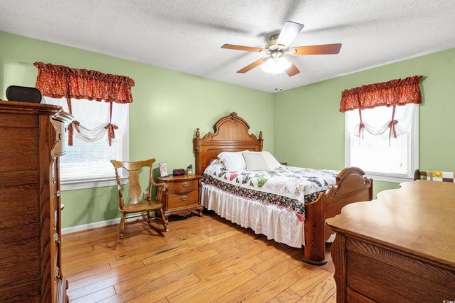Bedroom with light wood-style flooring, ceiling fan, baseboards, and a textured ceiling | Image 11