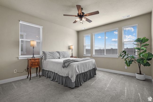 Bedroom featuring carpet flooring, baseboards, visible vents, and ceiling fan | Image 14