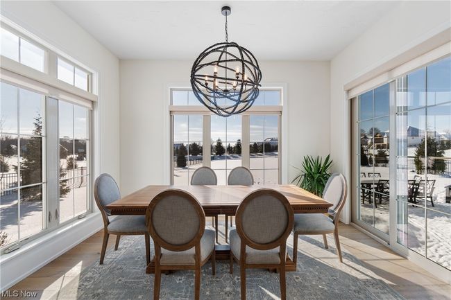 Dining room with a notable chandelier and light wood-type flooring | Image 13