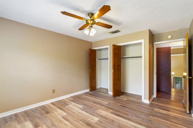 Bedroom has ceiling fan and double closet | Image 13