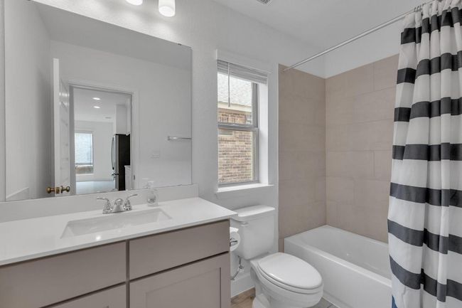 Bathroom with plenty of natural light, vanity, and shower / bath combination with curtain | Image 12