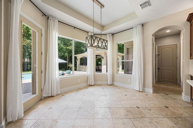 Elegant breakfast area with tray ceiling, designer light fixture, and neutral panels to accent your windows to the backyard. | Image 14