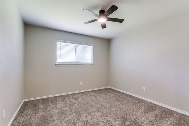 Carpeted spare room featuring ceiling fan and baseboards | Image 18