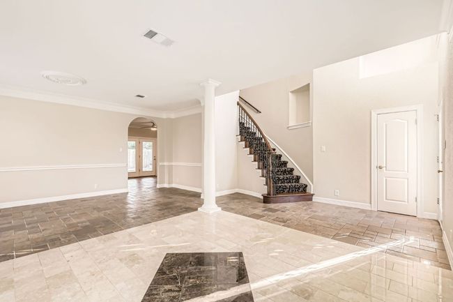 Spare room featuring arched walkways, baseboards, visible vents, and stairs | Image 18