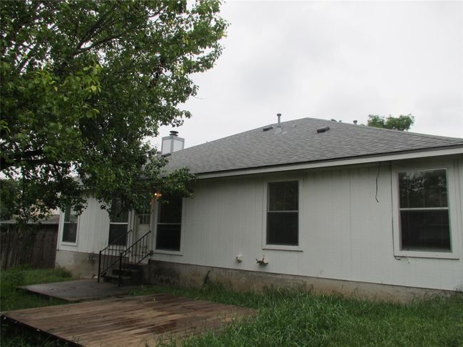 Back of house with roof with shingles, a chimney, and a patio area | Image 14