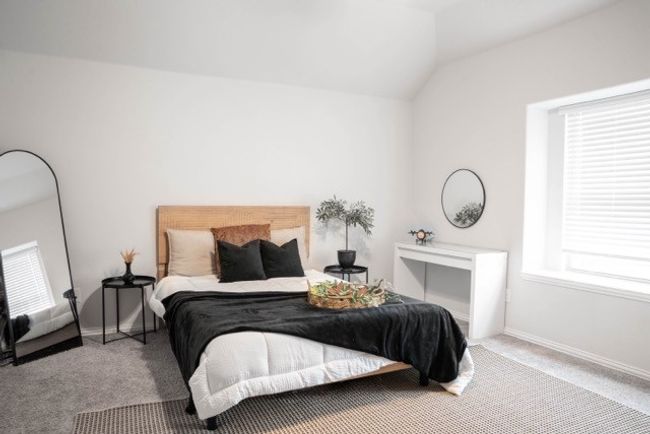 Carpeted bedroom with vaulted ceiling, baseboards, and multiple windows | Image 24