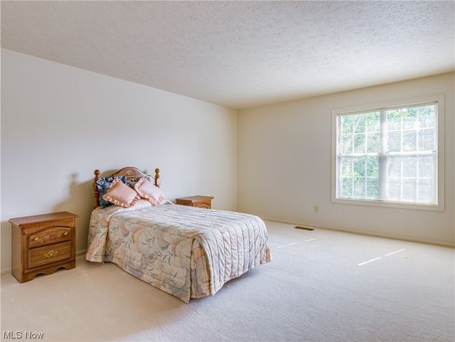 Carpeted bedroom with a textured ceiling | Image 26