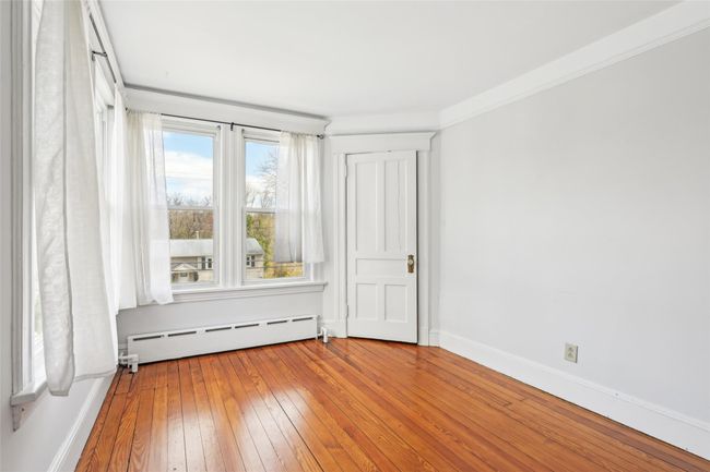 Unfurnished room with plenty of natural light, wood-type flooring, baseboard heating, and baseboards | Image 23