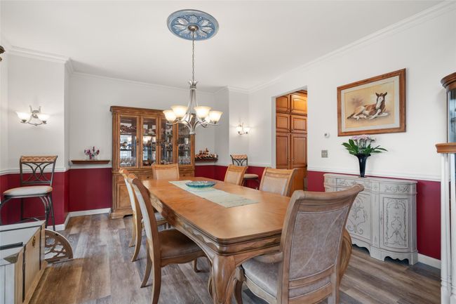 Dining room featuring an inviting chandelier, ornamental molding, wainscoting, and wood finished floors | Image 5