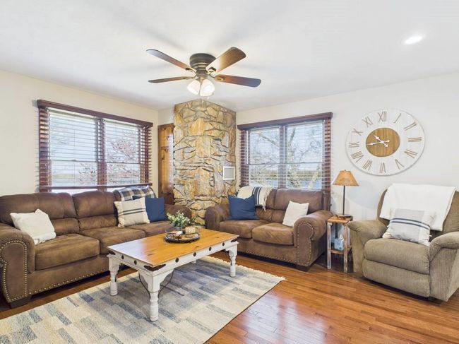 Living area with a ceiling fan and wood finished floors | Image 33