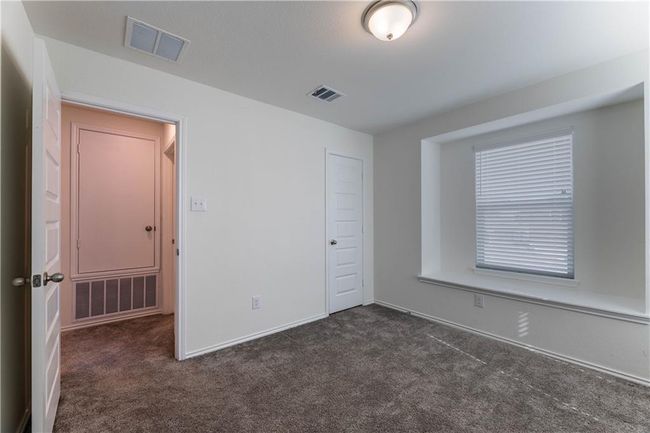 Unfurnished bedroom with dark colored carpet and a closet | Image 24
