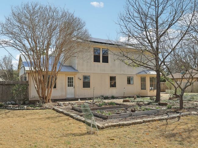 Rear view of property with a garden, solar panels, metal roof, fence, and a lawn | Image 29