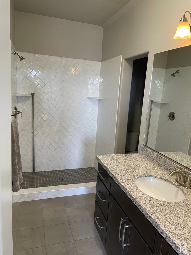 Full bathroom featuring walk in shower, tile patterned flooring, and vanity | Image 54