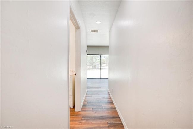 Hall with baseboards, visible vents, and wood finished floors | Image 26