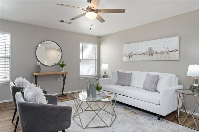 Living area featuring visible vents, wood finished floors, baseboards, and ceiling fan | Image 9