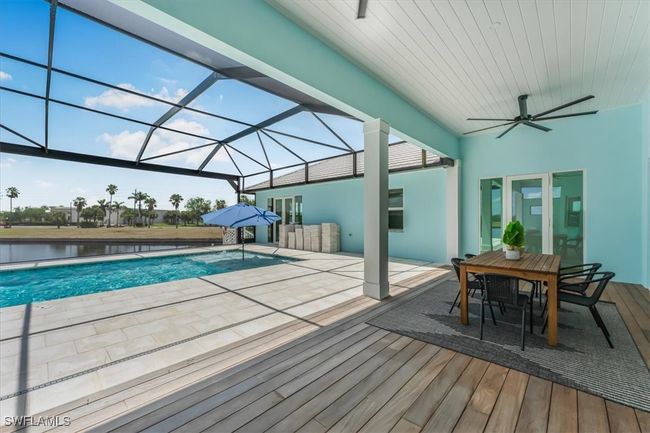 Swimming pool with a ceiling fan, a patio area, glass enclosure, and outdoor dining area | Image 32