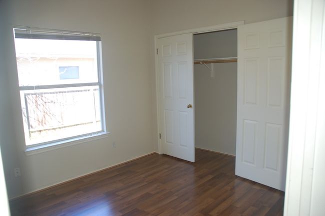 Unfurnished bedroom with dark wood-type flooring and a closet | Image 7