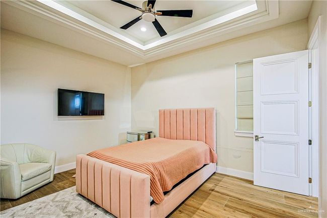 Upstairs bedroom with a tray ceiling, porcelain flooring, recessed lighting, and ceiling fan | Image 14