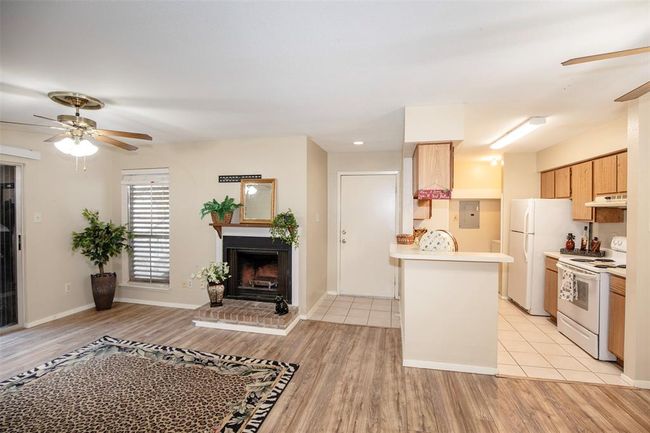 Step into this charming one-bedroom condo featuring an open-concept layout that seamlessly connects the family room, dining area, and kitchen. | Image 7