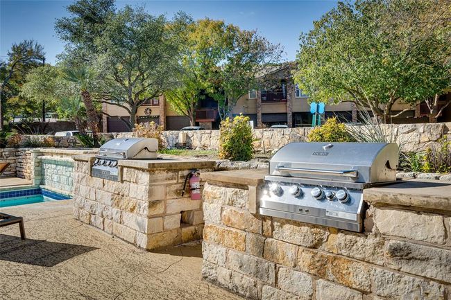 View of patio featuring area for grilling and a swimming pool | Image 17