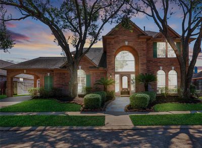 Stately curb appeal creates a commanding presence on the street with keystone arches and charming shutters on the all-brick front façade. Note the porte-cochere to the left, offering covered all-season parking with direct access to the home without having to use the garage. | Image 2