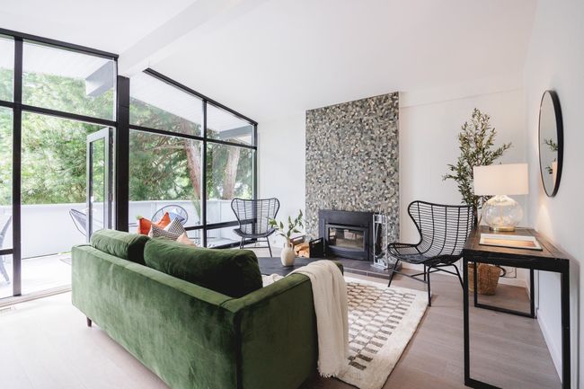 Living room featuring plenty of natural light, wood finished floors, a large fireplace, and floor to ceiling windows | Image 10