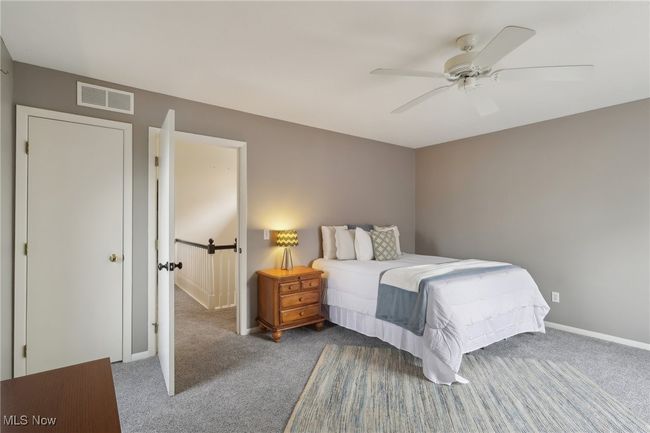 Carpeted bedroom with visible vents, ceiling fan, and baseboards | Image 30