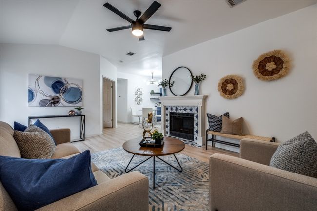 Living room with visible vents, light wood-type flooring, a ceiling fan, and vaulted ceiling | Image 8