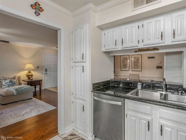 Kitchen featuring crown molding, a sink, dishwasher, white cabinetry, and visible vents | Image 14