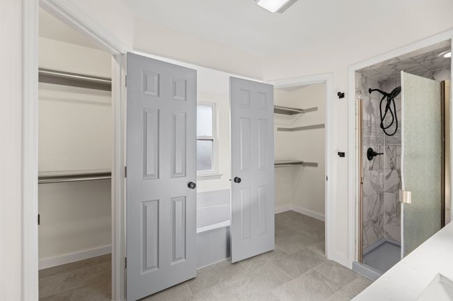 Bathroom featuring baseboards, a walk in closet, and a shower stall | Image 29