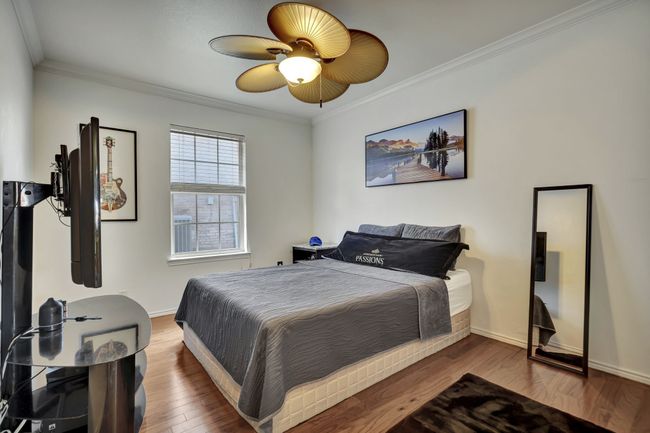 Bedroom featuring ceiling fan, hardwood / wood-style flooring, and crown molding | Image 28