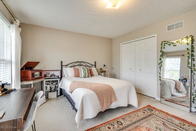 Carpeted bedroom with a closet and a textured ceiling | Image 29