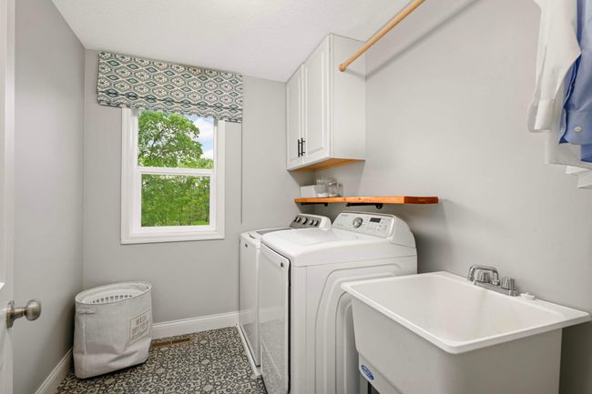 Upper-level laundry room with utility sink, cabinets, and fun flooring! | Image 33
