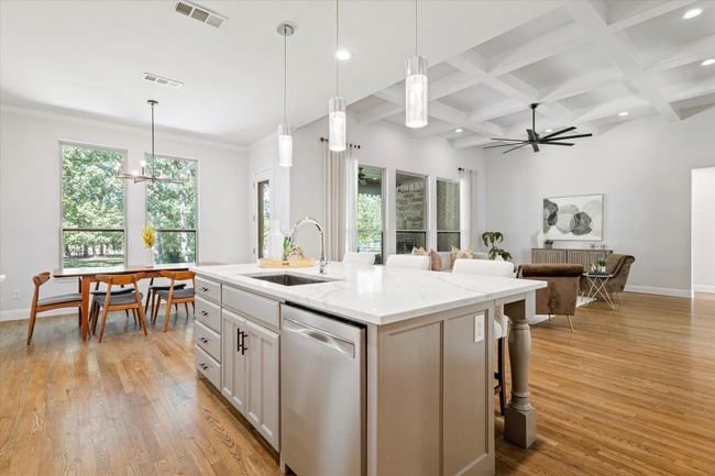 Kitchen featuring stainless steel dishwasher, a center island with sink, beam ceiling, a ceiling fan, and a kitchen breakfast bar | Image 13