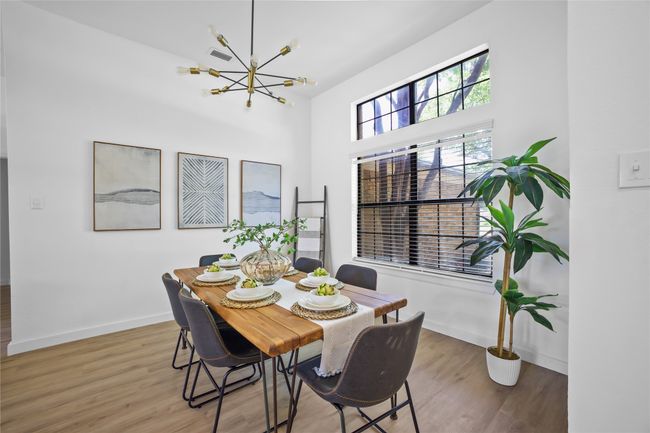 Dining area with a chandelier and wood finished floors | Image 4
