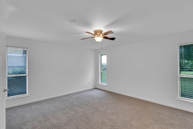Carpeted spare room featuring baseboards and ceiling fan | Image 27
