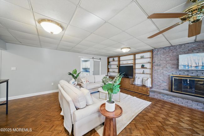 1st floor spacious living room with hw floors, fireplace, kitchenette nearby with sliders to level yard | Image 34
