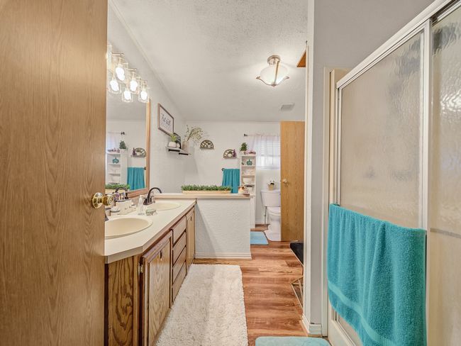 Bathroom featuring a separate shower , tub, wood look floors, double sinks, house one. | Image 11
