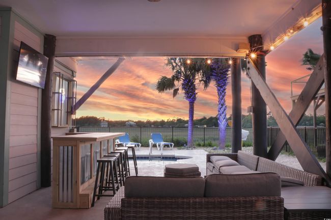 View of patio featuring a fenced in pool, a water view, fence, and an outdoor hangout area | Image 32