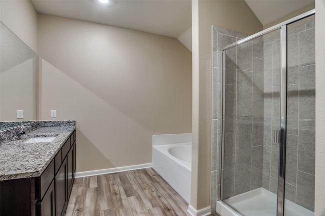 Bathroom featuring lofted ceiling, wood finished floors, and a stall shower | Image 8