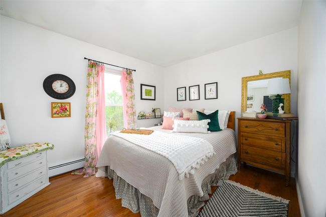 Bedroom with a baseboard radiator and wood finished floors | Image 20