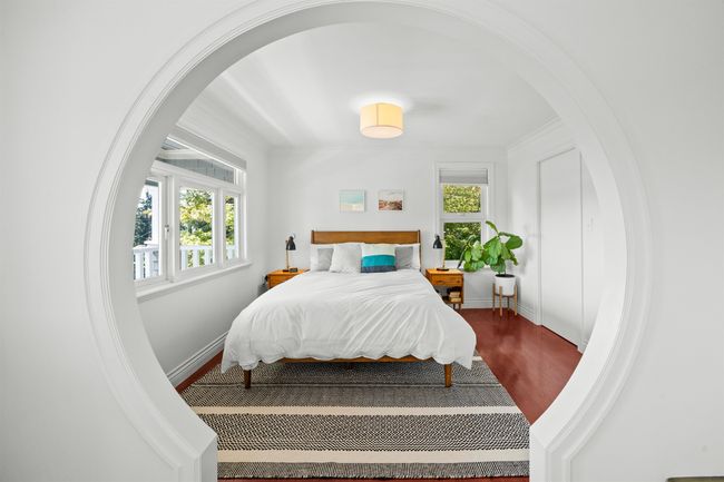 Bedroom with arched walkways, wood finished floors, and baseboards | Image 21