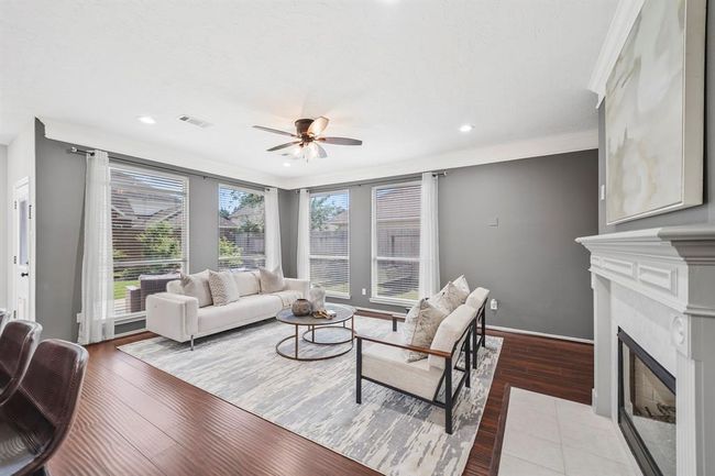 cozy living room with outlets for a tv behind art over fireplace. | Image 8