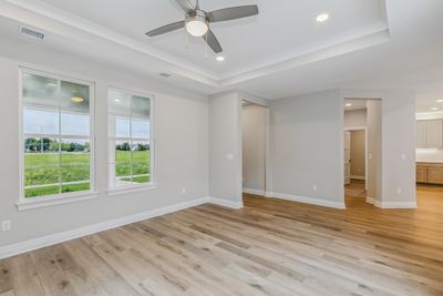 Unfurnished room with ceiling fan, light hardwood / wood-style floors, and a raised ceiling | Image 3