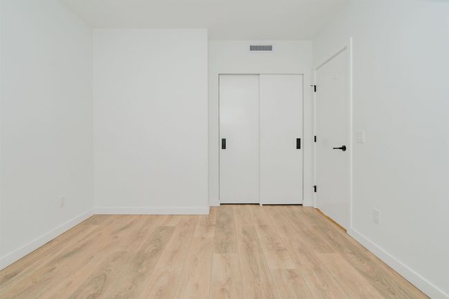Spare room with visible vents, baseboards, and wood finished floors | Image 24