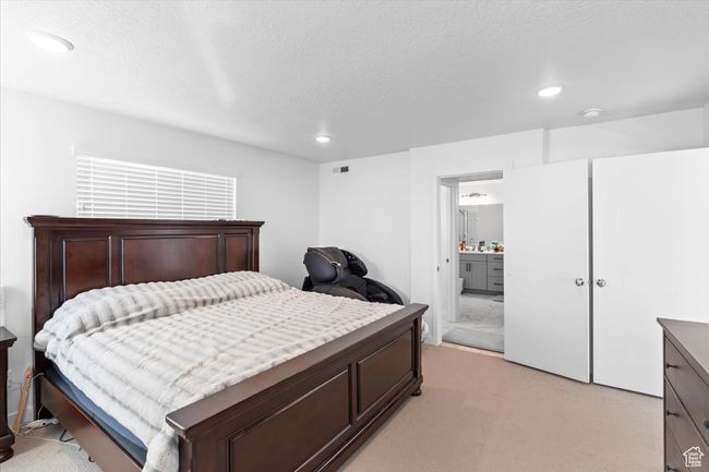 Bedroom featuring recessed lighting, visible vents, light colored carpet, and connected bathroom | Image 12