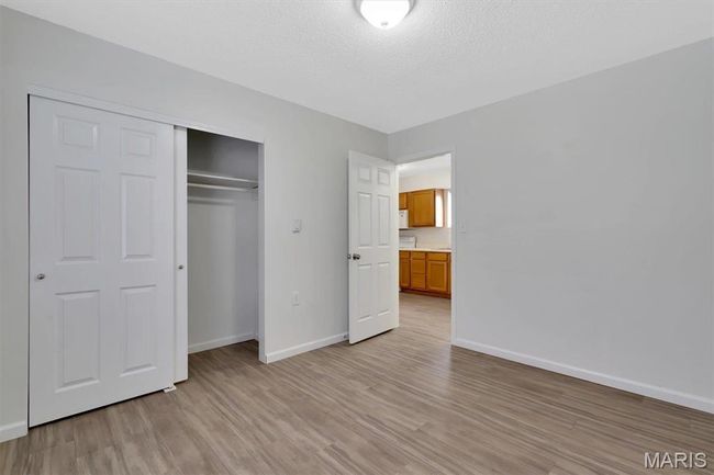 Unfurnished bedroom featuring a closet, a textured ceiling, and LVP floors | Image 12
